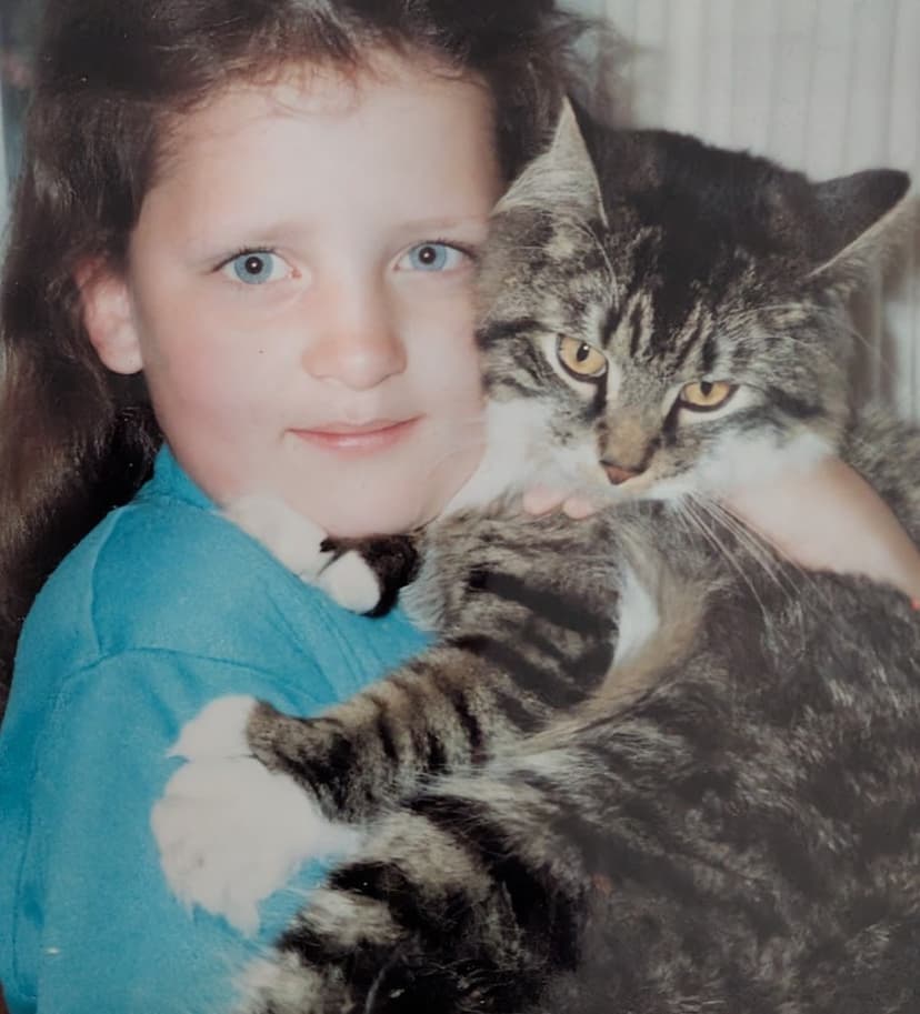 A young girl hugging Sparky, a fluffy tabby cat